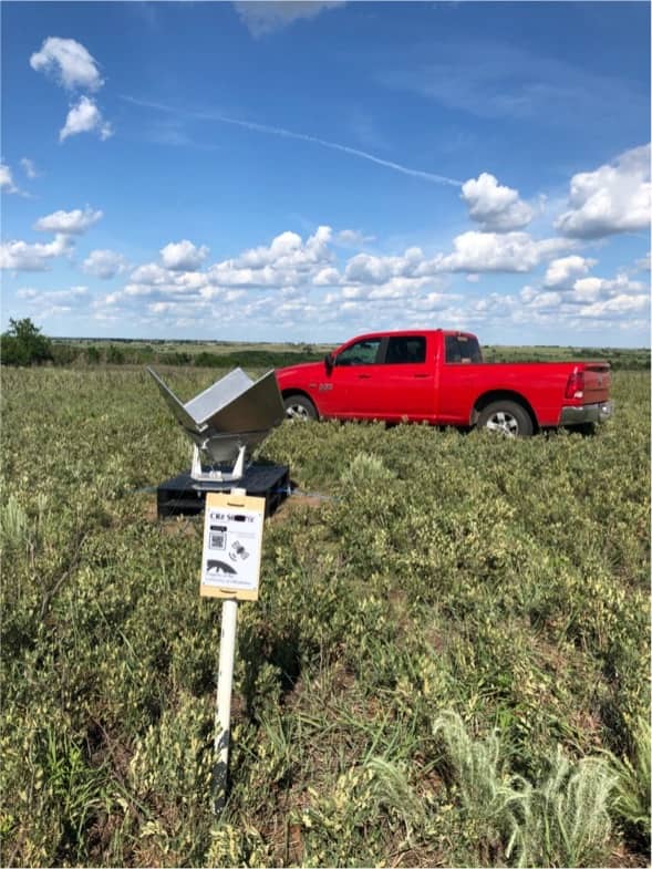 Metal corner reflector points at the sky in a grassy field