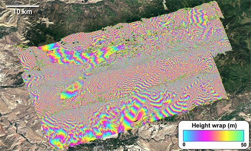 False-color radar image with rainbow fringes overlaid over Google Earth