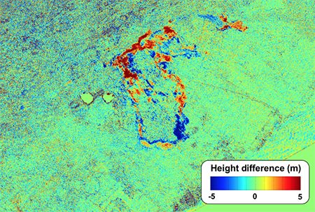 Bright green false-color image with lava flows shown in blue and red